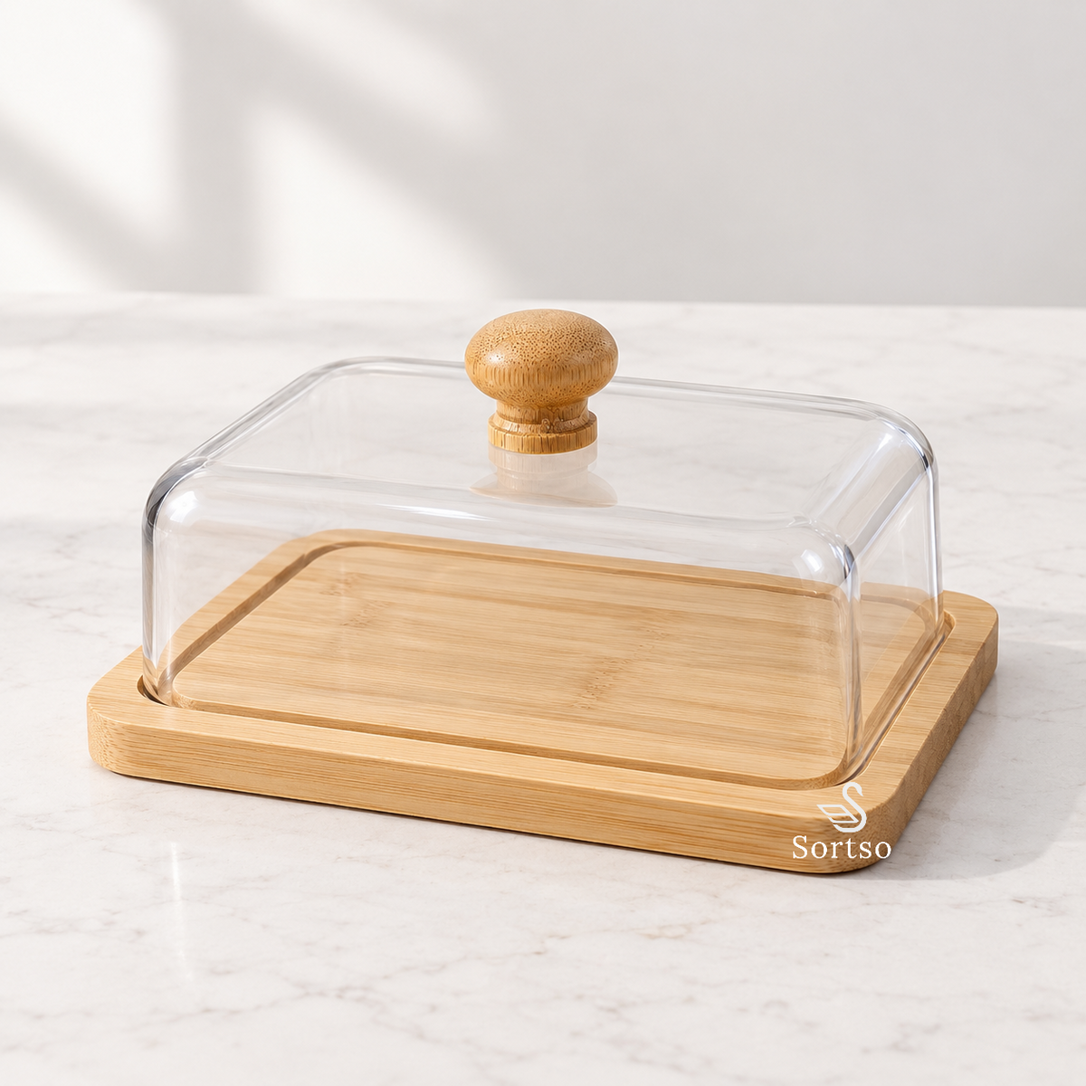 Bamboo butter dish with clear cover and wooden knob on countertop